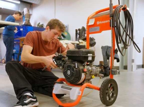 A fixer rebuilding a pressure washer engine